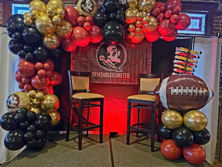 Garnet, chrome gold and black two-piece balloon set framing a Seminoles United banner with a football foil balloon