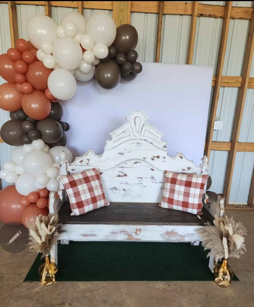 Terracotta, white and mocha balloon garland over a white backdrop and farmhouse bench